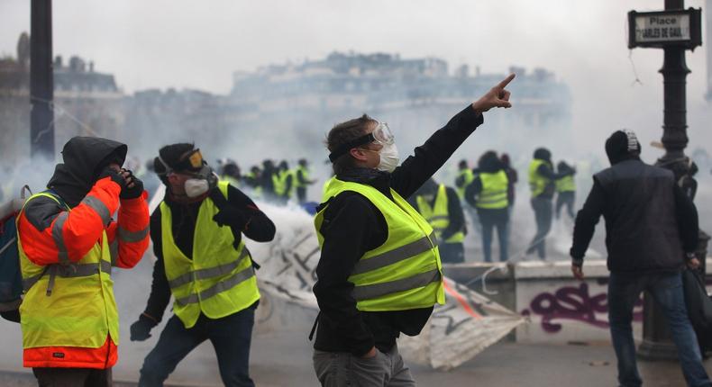 PARIS, FRANCE - DECEMBER 01: Yellow vest protesters clash with riot police as part of demonstration against rising fuel taxes near Arc de triomphe de l'Etoile in Paris, France on December 01, 2018.