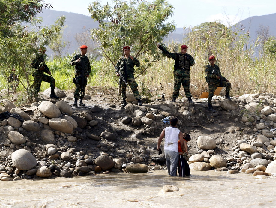 Venezuelan national guards deny the entry of a man and his son to Venezuela in the Tachira River, close to Villa del Rosario village, Colombia, August 26, 2015.
