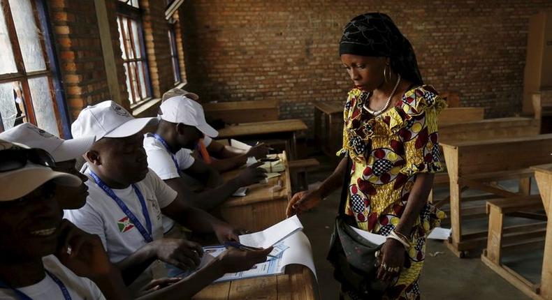 A woman receives ballot papers from election officials at a voting station in Burundi's capital Bujumbura during the country's presidential elections, July 21, 2015. REUTERS/Mike Hutchings