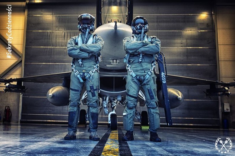 Dwaj polscy piloci wojskowi na tle stacjonującego w Krzesinach F-16C Block 52+.