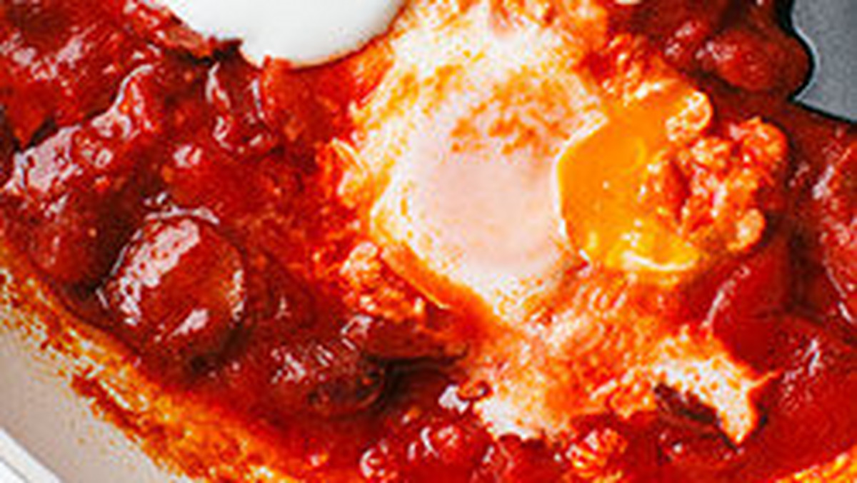 Szakszuka, czyli jajka gotowane w pomidorach, to propozycja na lekkie śniadanie bez pieczywa. Latem najlepiej sprawdzają się świeże pomidory, zimą można je zastąpić tymi z puszki. Warto dodać też kiełbaskę chorizo i fasolę.
