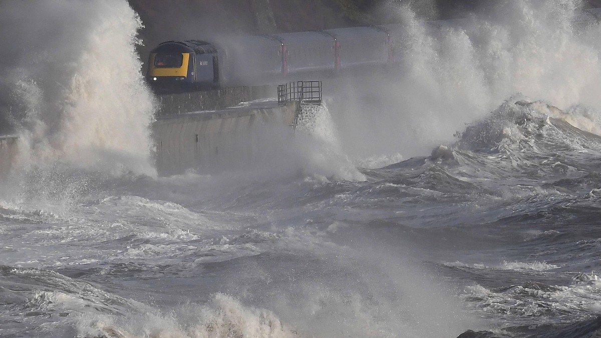 Waves hit a train during heavy seas and high winds in Dawlish in south west Britain