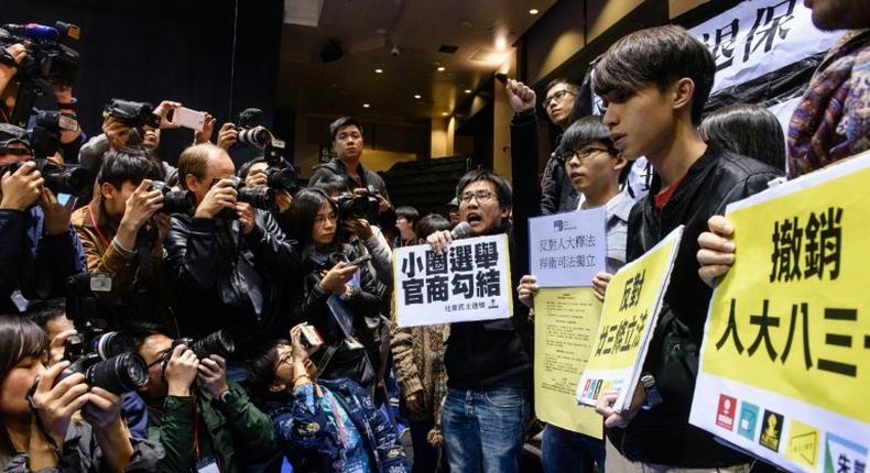 Pro-democracy protesters (R) shout slogans against former Hong Kong chief secretary and leadership hopeful Carrie Lam (not seen) before the start of a press conference by Lam in Hong Kong on February 27, 2017