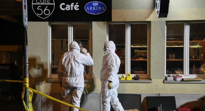 Police collect evidence at the site of a shooting in the Swiss city of Basel on March 9, 2017 which left two people dead and one seriously injured