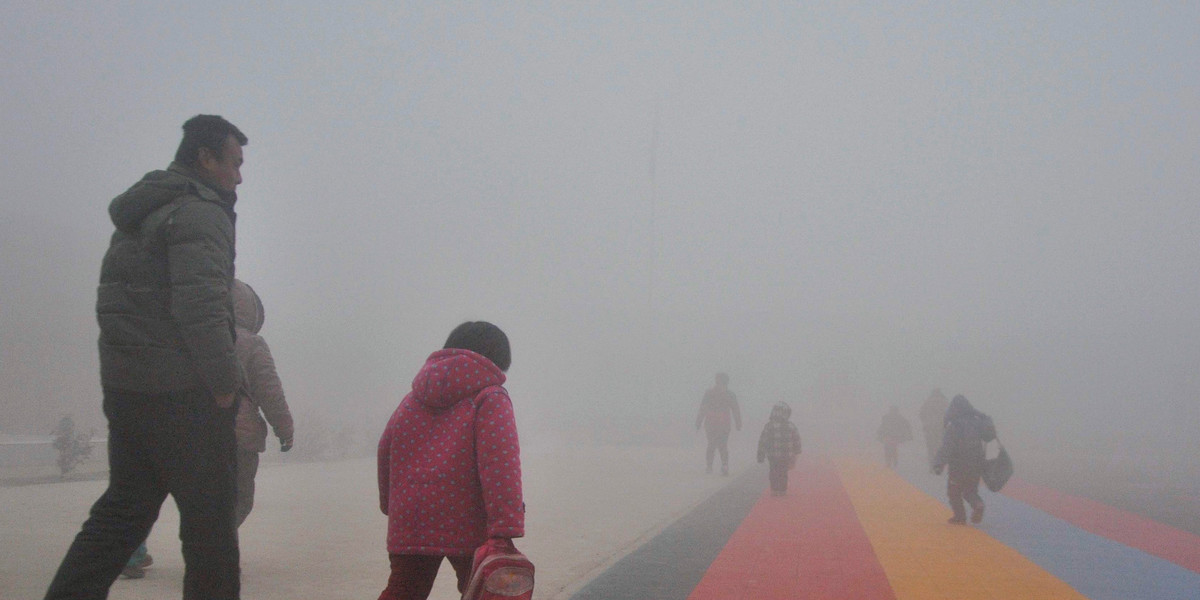 Parents walk primary school students to school amid thick haze in Chiping county, Shandong province January 16, 2015. The National Meteorological Center of China Meteorological Administration (CMA) issued a yellow smog alert early on Wednesday, predicting that smog will persist in most parts of the country for the upcoming days, Xinhua News Agency reported.
