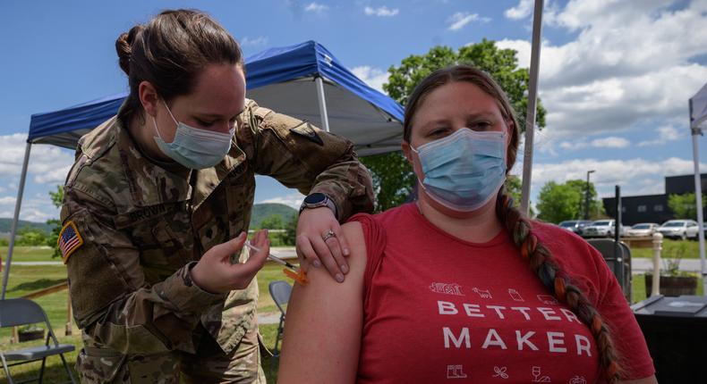 An employee receives a COVID-19 vaccine from a National Guard soldier at a pop-up vaccination stand at the Vermont Creamery in Websterville, Vermont on June 29, 2021.
