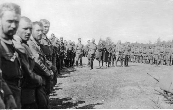 Uroczystości z okazji ostatecznego uznania 7 pułku Legionów. W środku, pierwszy z prawej, obok Piłsudskiego, stoi Żymierski (domena publiczna).