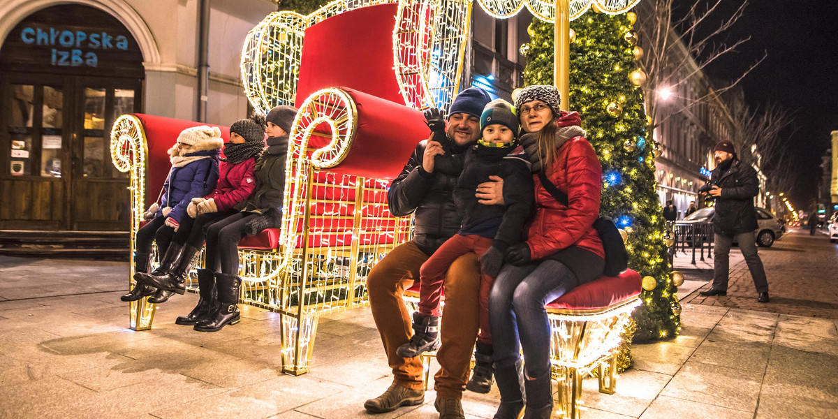 Łódź w świątecznej iluminacji. Ulica Piotrkowska z choinką, gwiazdkami i fotelem świętego Mikołaja