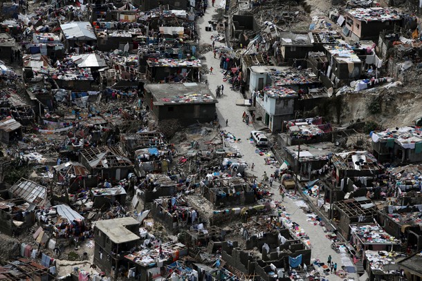 People walk on a street next to destroyed houses after Hurricane Matthew hit Jeremie