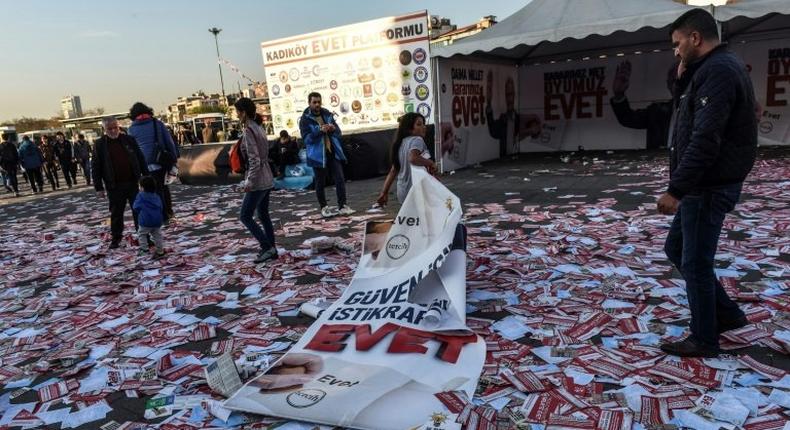 A girl drags a banner reading yes across piles of yes leaflets in the Kadikoy district of Istanbul