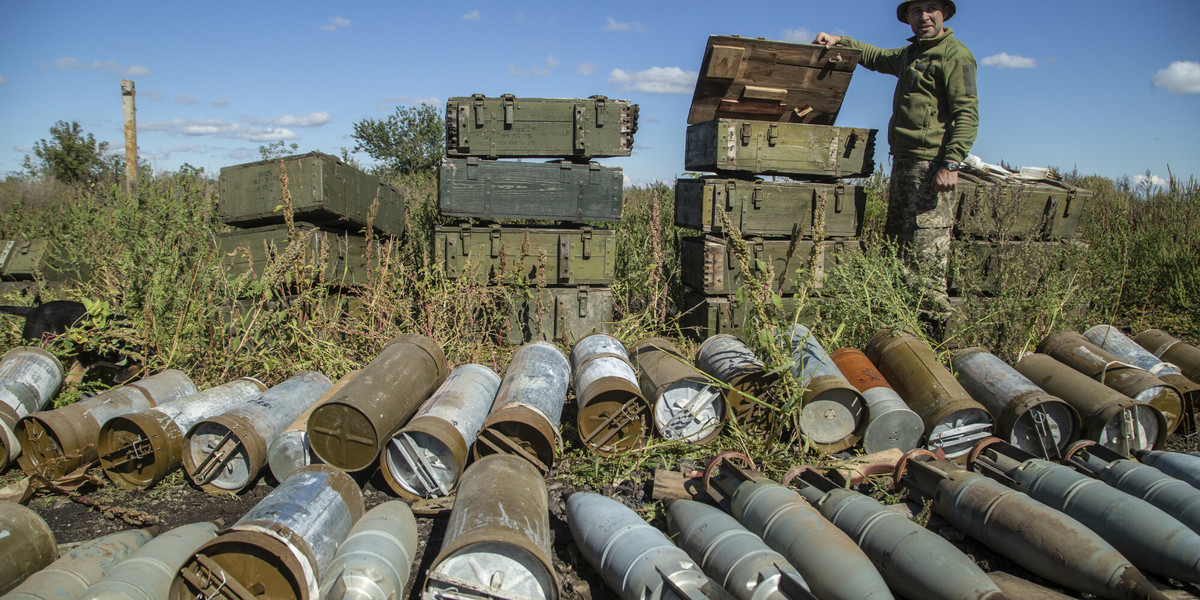 Ukraiński żołnierz sprawdza amunicję pozostawioną przez wojska rosyjskie na niedawno odbitym obszarze w pobliżu Izium na Ukrainie, 21 września 2022 r.