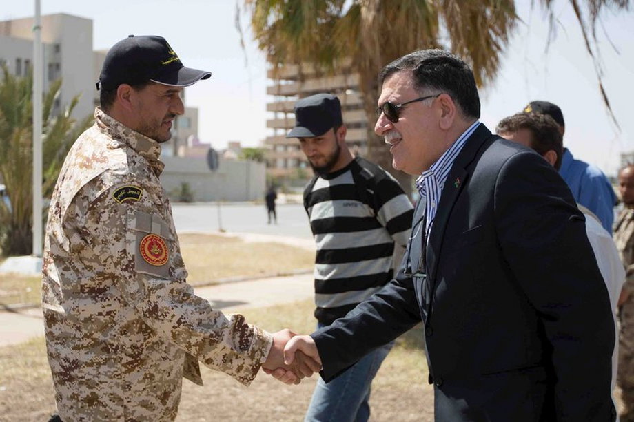 Handout photo of unity-government head Seraj shaking hands with a soldier during a tour of Martyrs' Square in Tripoli.