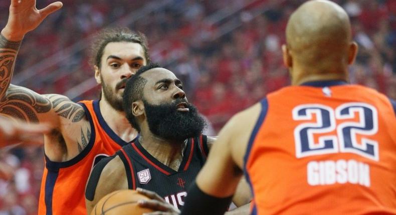 James Harden (C) of the Houston Rockets drives to the basket past the Oklahoma City Thunder players during the 2017 NBA playoffs' first round, in Houston, Texas, on April 16, 2017