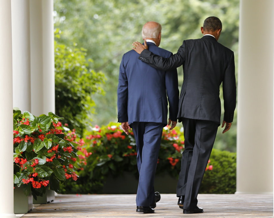 Obama and Biden walk back to the Oval Office after speaking about the Supreme Court ruling to uphold the nationwide availability of tax subsidies under Obamacare.