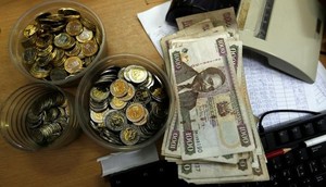 Kenya shilling coins and notes are pictured inside a cashier's booth at a forex exchange bureau in Kenya's capital Nairobi, April 20, 2016. REUTERS/Thomas Mukoya