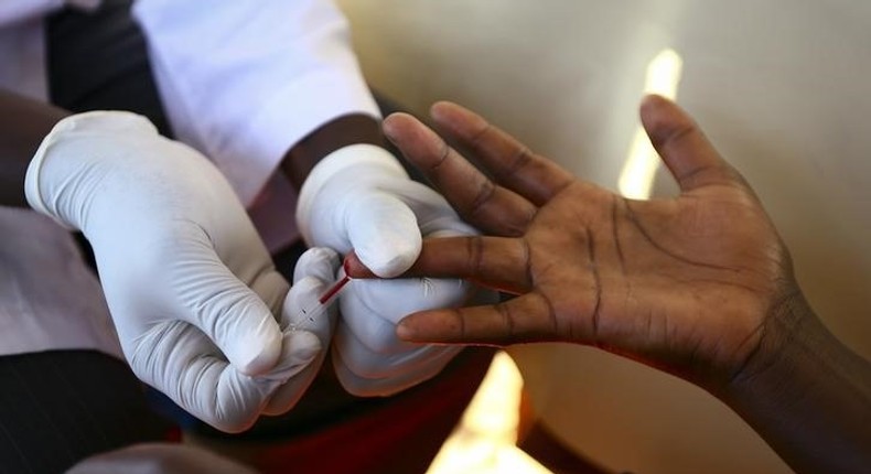 A doctor draws blood from a man to check for HIV/AIDS at a mobile testing unit in Ndeeba, a suburb in Uganda's capital Kampala May 16, 2014. 