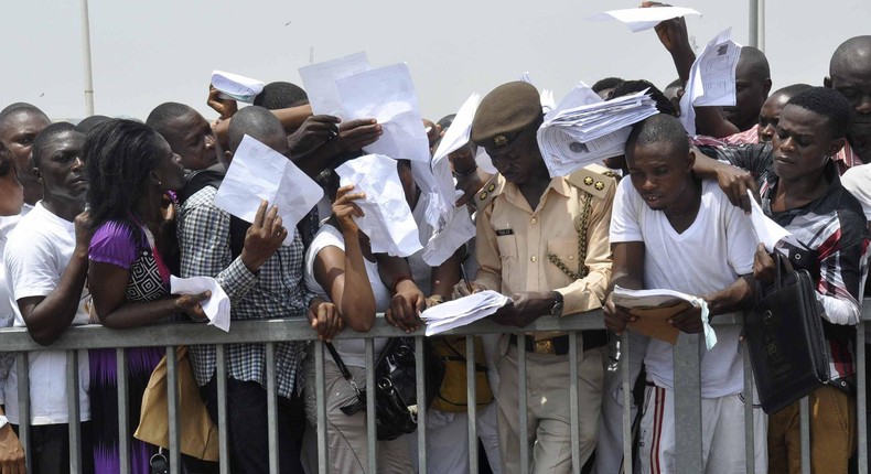 Job-seekers lie on the pitch after a stampede in Abuja National Stadium during the Nigerian immigration recruitment in 2014. 