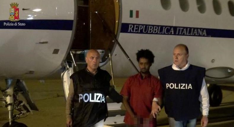 Medhanie Yehdego Mered (C), 35, is pictured with Italian policemen as they land at Palermo airport, Italy, following his arrest in Khartoum, Sudan, on May 24.   REUTERS/File Photo