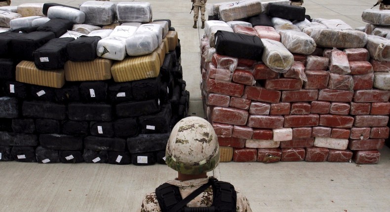 Mexican soldiers stand guard next to packages of marijuana at a military base in Tijuana, June 13, 2015.
