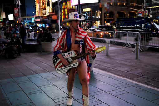 A Naked Cowboy performer supporting Donald Trump walks through Times Square in New York