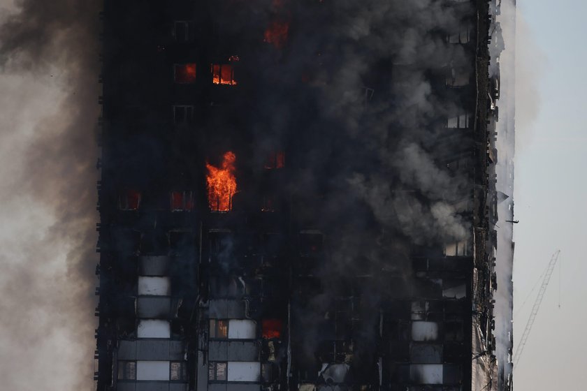 Police officers cordon off an area close to the scene of a serious fire in a tower block at Latimer 