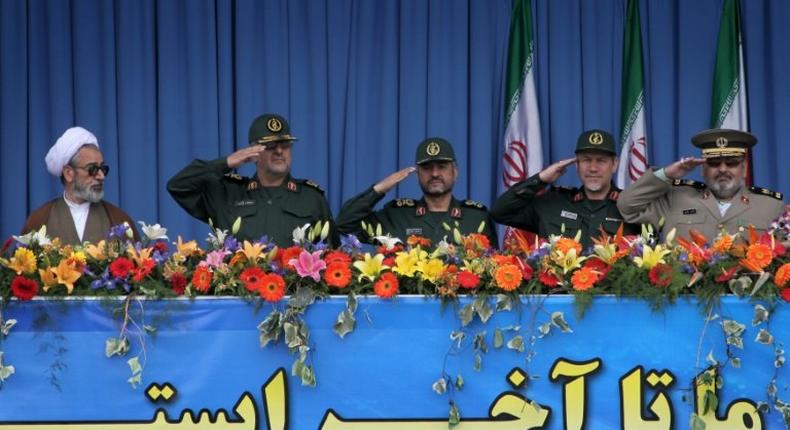 A clergyman looks towards top Iranian military commanders including (L) Mohammad Pakpour, head of ground forces of the Revolutionary Guards, during the Army Day parade in Tehran on April 18, 2010