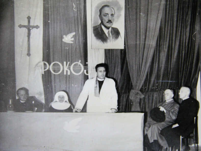 26 czerwca 1951 r. w sali Domu Drukarza w Gdańsku odbyło się zebranie duchowieństwa „postępowego” poświęcone akcji zbierania podpisów pod apelem Światowej Rady Pokoju. Na zdjęciu widzimy charakterystyczne dla spotkań księży „patriotów” elementy: krzyż, portret Bolesława Bieruta oraz gołąbek pokoju.