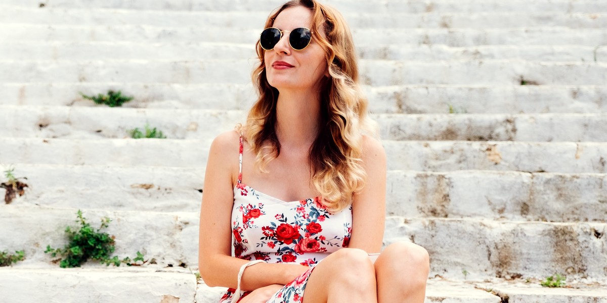 Beauty young woman in dress sitting on steps