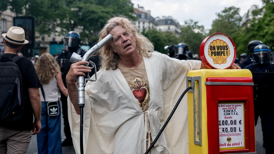 Muškarac sa maketom benzinske pumpe na ulicama Pariza | Foto: Reuters
