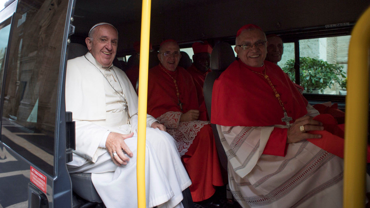 Pope Francis sits in a bus with the new cardinals as they travel to meet Pope Emeritus Benedict XVI  following a consistory ceremony in Saint Peter's Basilica at the Vatican