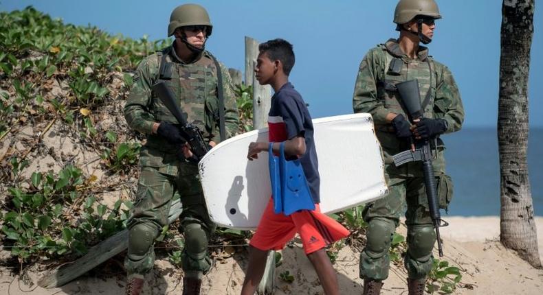 Brazilian soldiers stand guard on Ipanema beach in Rio de Janeiro on July, 29, 2017, following the government decision to deploy some 8,500 troops in the city to fight organized crime and a spike in street violence