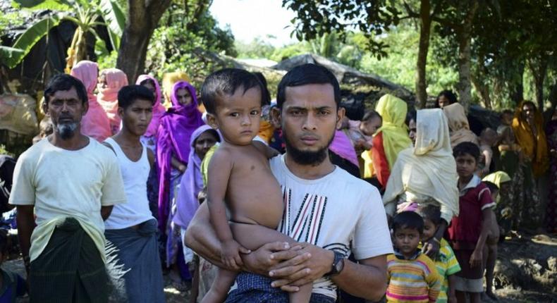 Rohingya refugee Mohammad Ayaz holds his son Mohammad Osman, the two survivors of their family, at an unregistered refugee camp at Ukhiya in southern Cox's Bazar district of Bangladesh on November 24, 2016