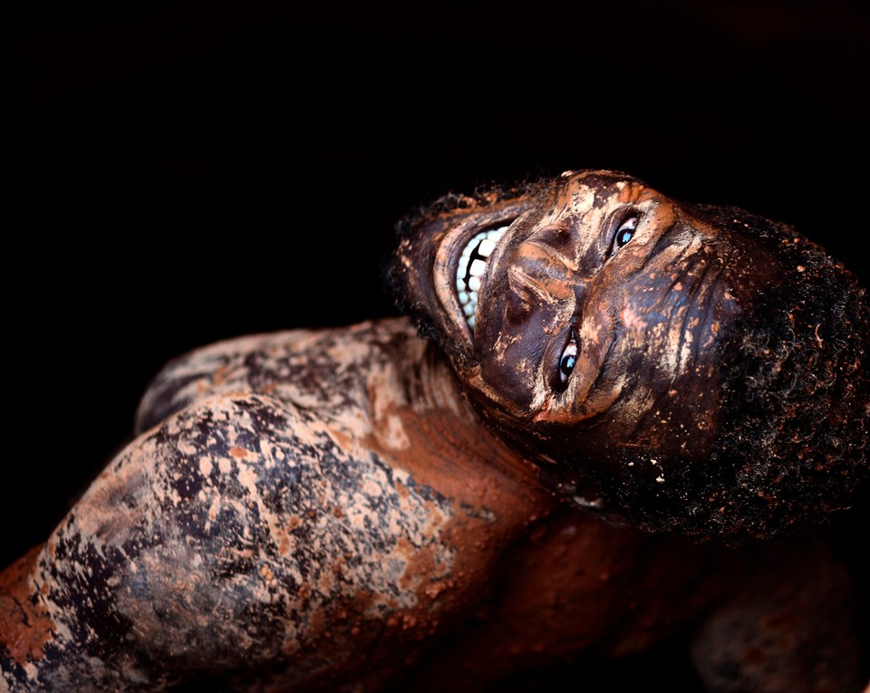 A gold miner smiles as he climbs down into a mine shaft in Manica Province