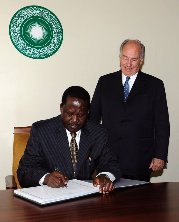 His Highness the Aga Khan watches as Raila Odinga signs the guest book commemorating the Foundation Ceremony of the Aga Khan University Graduate School of Media and Communications in Nairobi.. 