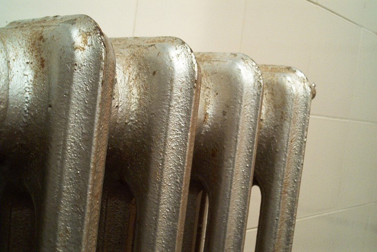 Oprócz udrożnienia przepływu powietrza, można jeszcze dodatkowo usprawnić system ogrzewania w każdym domu. Wystarczy pomiędzy ścianą zewnętrzną a grzejnikiem zainstalować ekran odbijający ciepło do środka. Choć „zainstalować ekran” brzmi jak skomplikowana operacja, to wcale tak nie jest. Chodzi po prostu o arkusz folii aluminiowej przyklejony np. na styropianie. Ekran taki odbija wytwarzane przez grzejnik ciepło od ściany zewnętrznej zmniejszając przy tym straty energii. Jego koszt to nie więcej niż 20 zł. W zamian za to możemy oszczędzić kilka proc. energii, co w skali roku pozostawi w portfelu 70-100 zł. Ekrany niewiele pomogą jedynie przy nowoczesnych grzejnikach i dobrze zaizolowanych ścianach. Szczególnie duży efekt przyniosą za to w mieszkaniach ze słabo zaizolowanymi ścianami i żeliwnymi starymi kaloryferami.