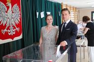Krzysztof Bosak (C) z żoną Kariną (L) podczas głosowania w lokalu wyborczym w XXX LO im. Jana Śniadeckiego w Warszawie.