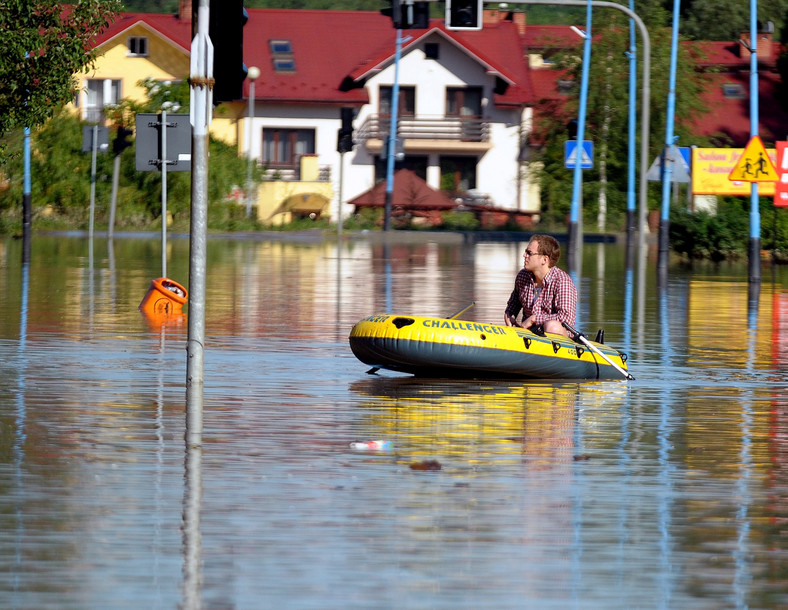 Jasło, 05.06.2010. Mężczyzna płynie pontonem jedną z zalanych ulic w Jaśle, 5 bm. W Jaśle, zalanym przez rzekę Ropę, trwa ewakuacja. (mr) PAP/Darek Delmanowicz