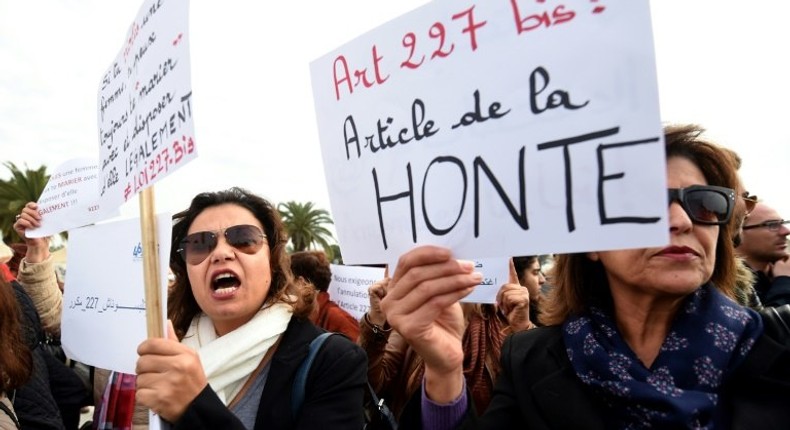 Dozens of people stage a protest outside of Tunisian parliament denouncing a law that allows men who rape underage girls to avoid punishment by marrying their victims