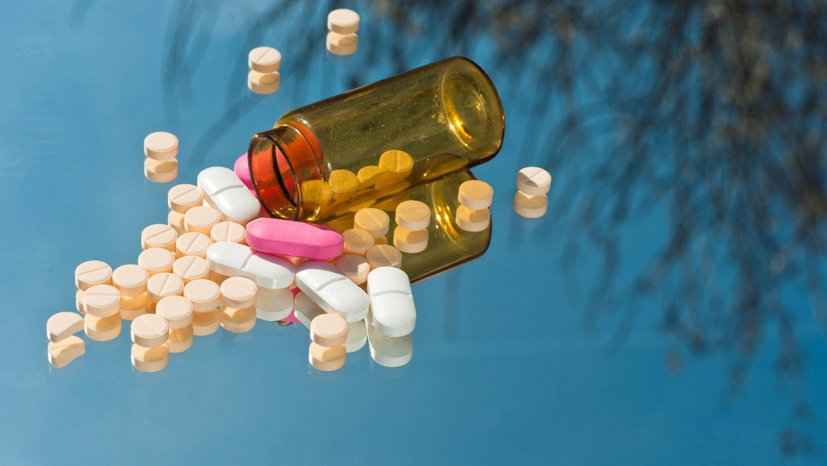 Medicine bottle with reflection and pills