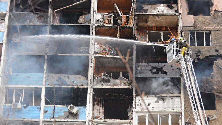 Ukraińscy strażacy gaszą pożar w budynku mieszkalnym po rosyjskim ataku rakietowym w Kijowie 