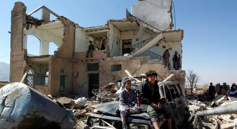 Children sit amidst the rubble of a house hit by Saudi-led coalition air strikes on the outskirts of the Yemeni capital Sanaa on November 14, 2016