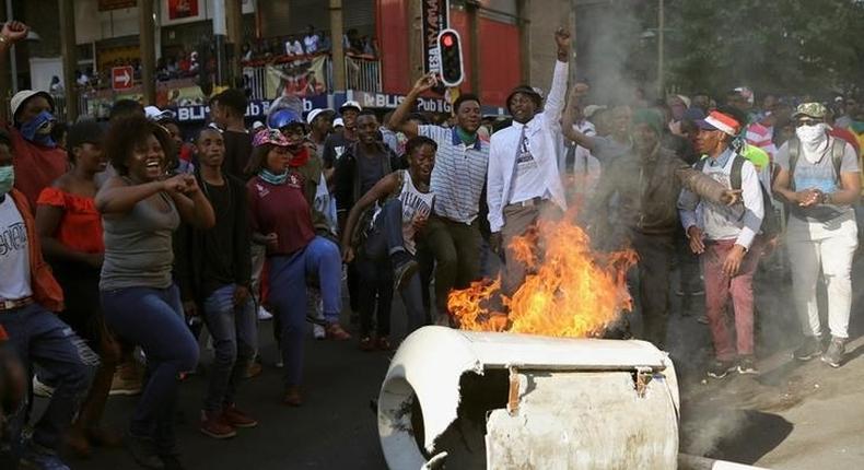 Students demanding free education chant slogans in front of burning barricade outside the University of the Witwatersrand at Braamfontein, in Johannesburg, South Africa