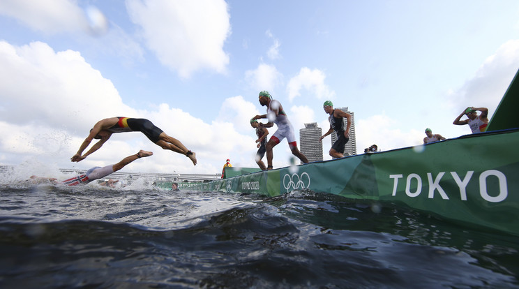 Versenyzők a vízbe ugranak a tokiói nyári olimpia triatlonversenyében az Odaiba Tengeri Parkban 2021. július 26-án /MTI/AP/Reuters pool/Antonio Bronic