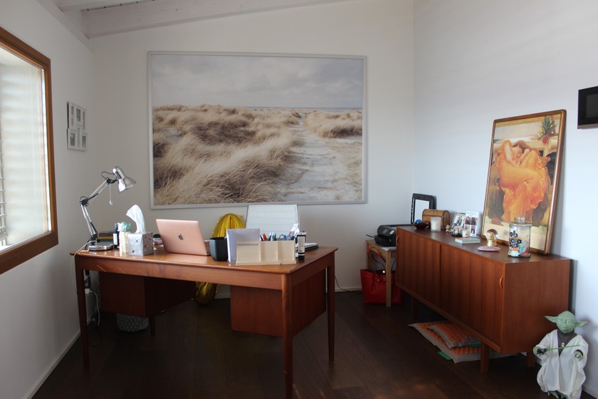 Die Familienmutter arbeitet von zu Hause aus und hat im Hintergrund für Videocalls ein Bild ihres geliebten Meeres. 