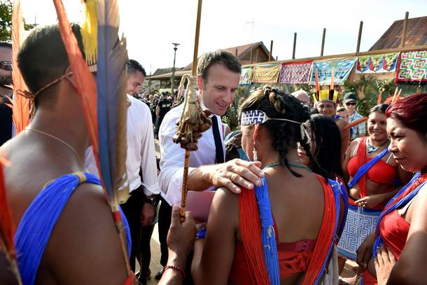 French President Emmanuel Macron greets locals during a visit to Maripasoula, part of his trip to Fr