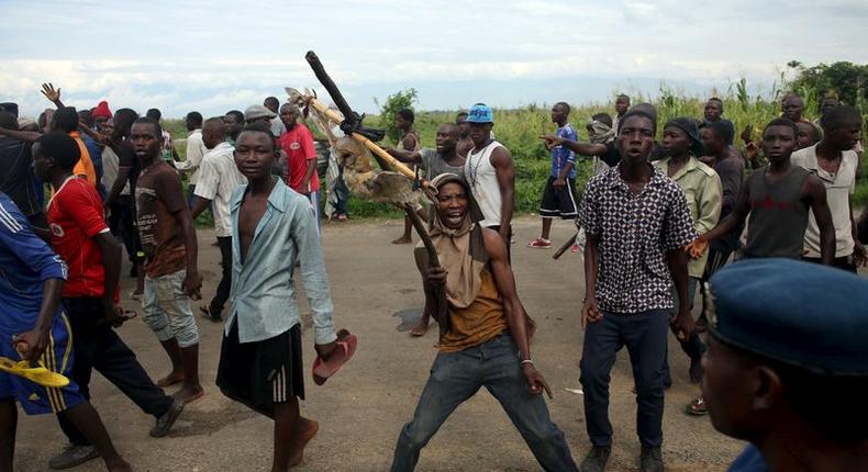 A protestor holds up a dead owl attached to a stick, intended to denigrate the ruling party whose emblem is an eagle, during a protest in Buterere neighbourhood of Bujumbura, Burundi May 12, 2015.    REUTERS/Goran Tomasevic