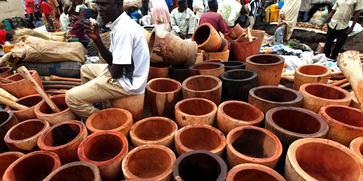 A man sits near mortars arranged in a local market in Suleja town on the outskirts of Nigeria's capital, Abuja, on July 29, 2010.