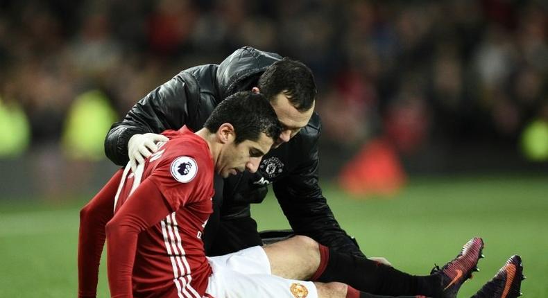 Manchester United midfielder Henrikh Mkhitaryan receives attention after picking up an injury during the English Premier League match against Tottenham Hotspur at Old Trafford on December 11, 2016