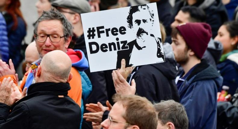 An activist displays a placard calling for Deniz Yucel's release during a concert organised in front of Berlin's Brandenburg Gate on the occasion of International Press Freedom Day on May 3, 2017