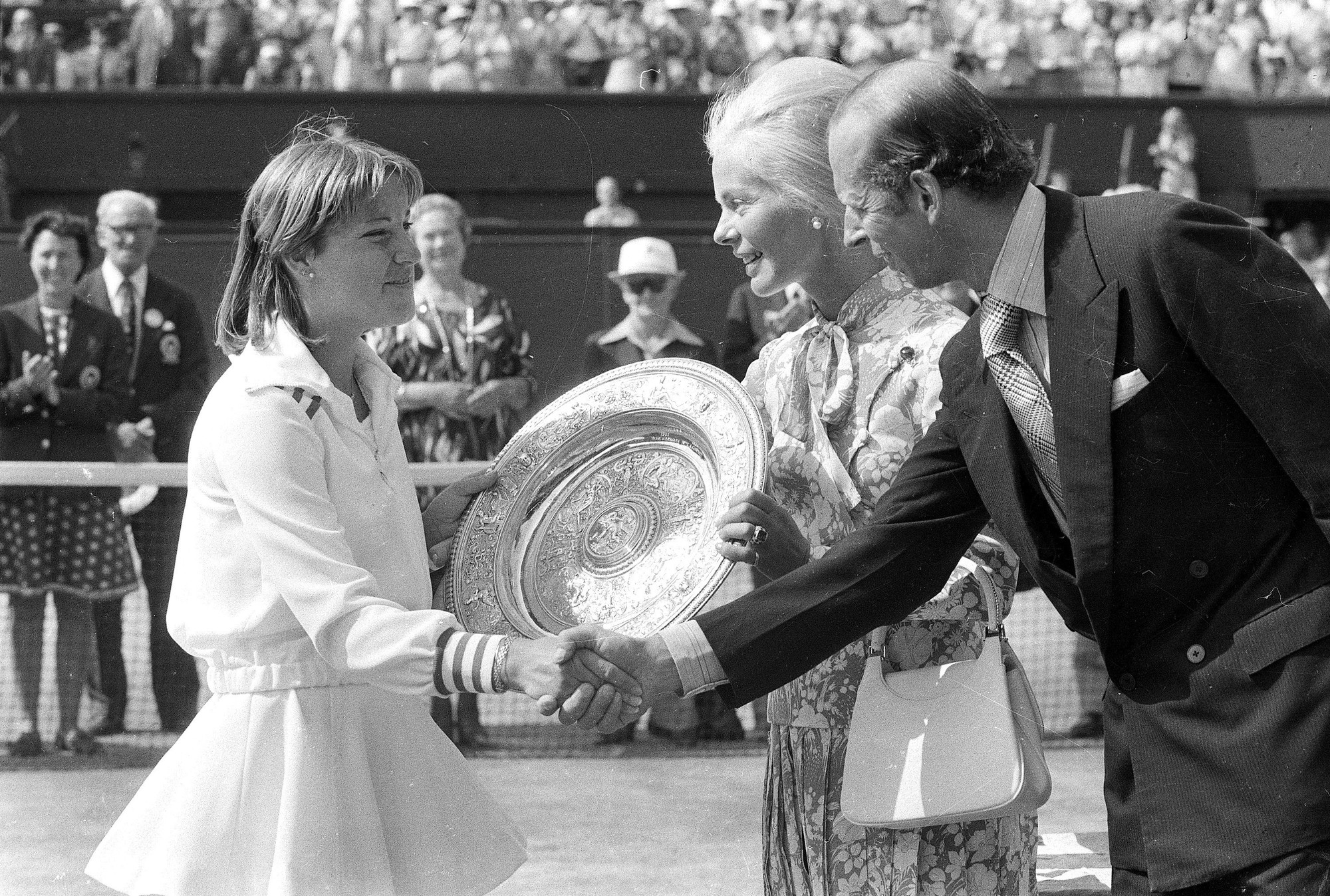 Na archívnej snímke z 2. júla 1976 vojvodkyňa z Kentu (uprostred) odovzdáva trofej americkej tenistke Chris Evertovej po víťazstve nad Austrálčankou Evonne Goolagongovou Cawleyovou vo finále ženskej dvojhry na grandslamovom turnaji vo Wimbledone, vpravo vojvoda z Kentu. 